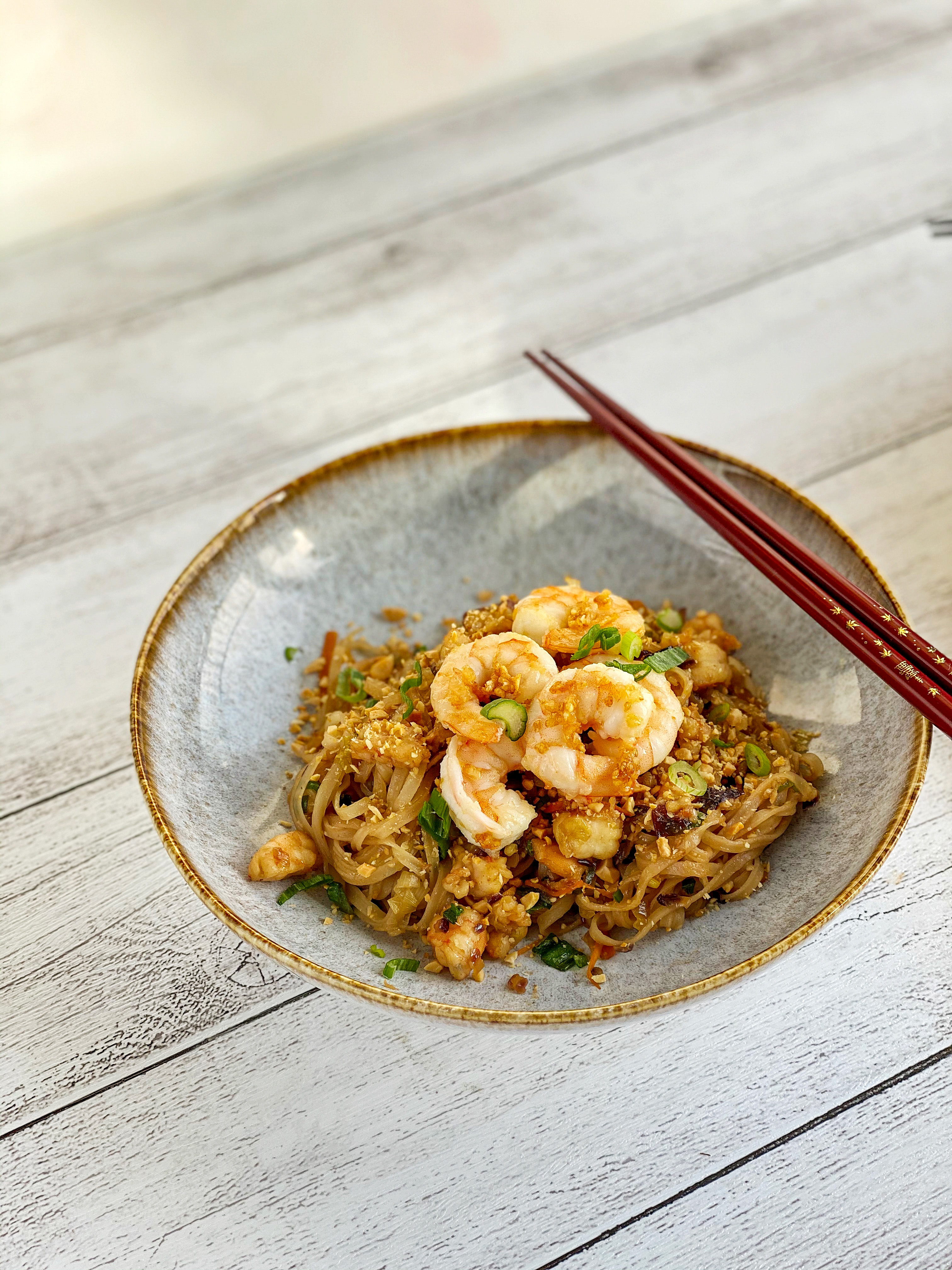 Shrimp  Pad Thai made with rice noodles, tamarind sauce, shrimps, carrots, onions, a sprinkle of peanuts. 