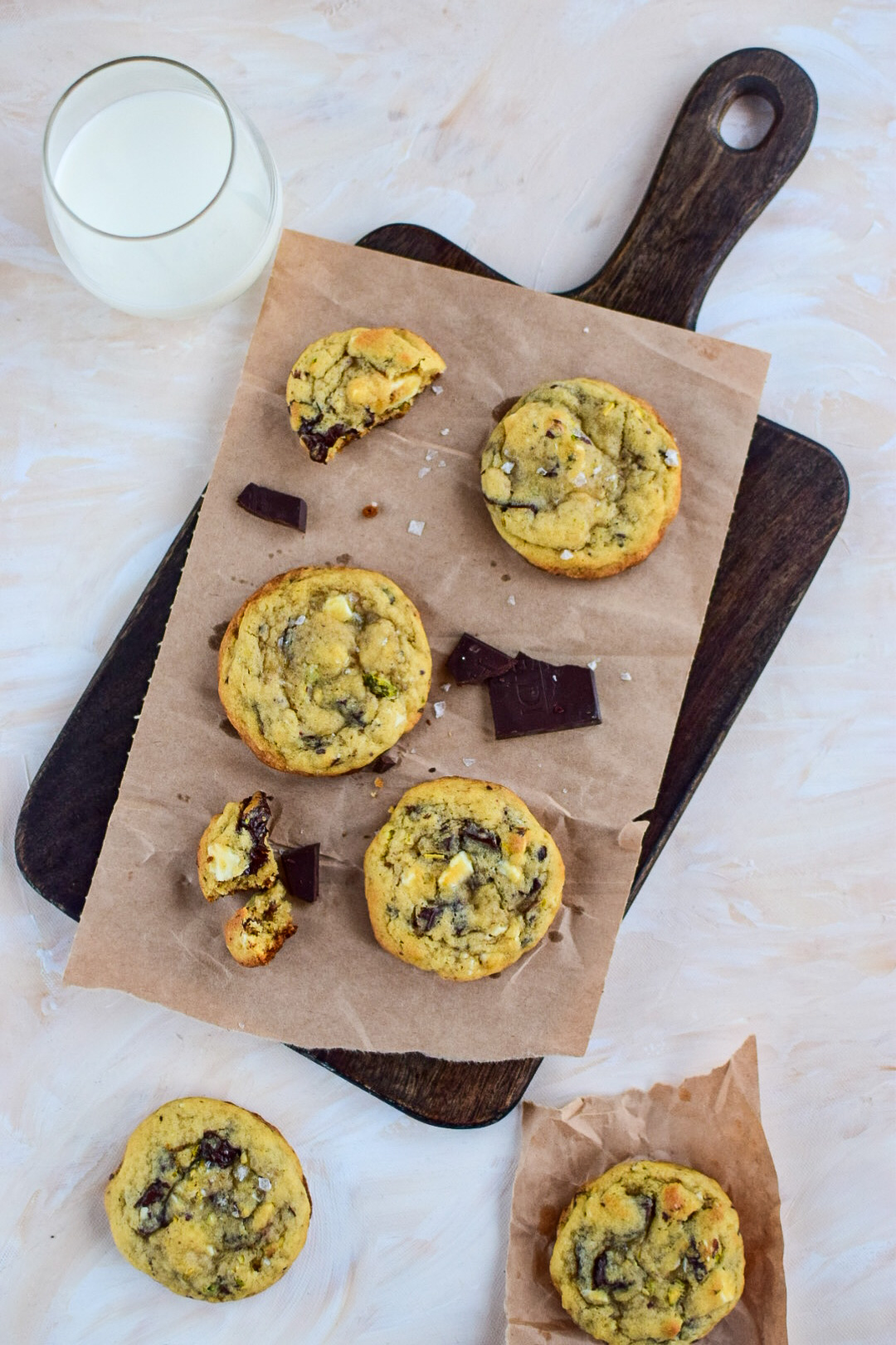 Chocolate cookies on brown paper, with a glass of milk